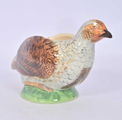 a ceramic bird that is sitting on a green base