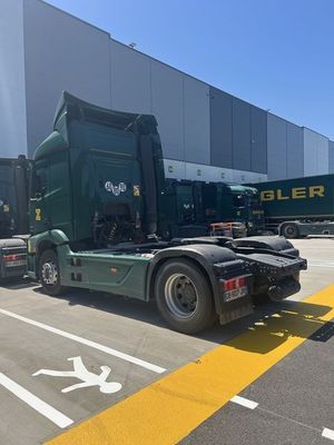 un camion vert garé devant un immeuble
