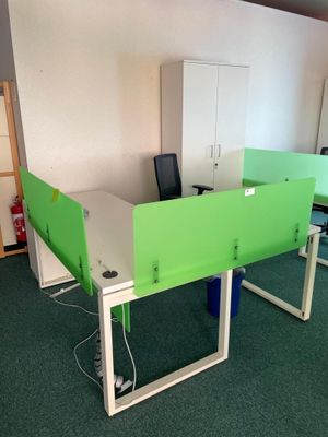 two green desks in a room with green carpet