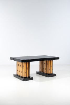 une image représentant une table en bois avec un plateau noir posée sur une surface blanche