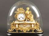 une horloge en or sous un dôme de verre sur une table