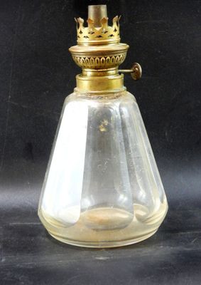 une lampe à huile à l'ancienne avec un abat-jour en verre, sur fond noir