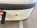 a person holding a measuring tape on a car ' s bumper