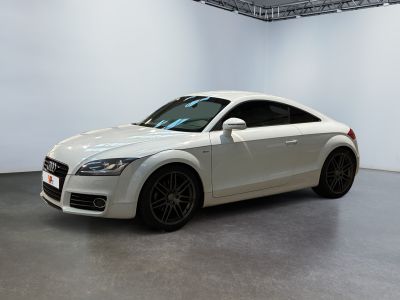 white audi tt with black rims parked in a white room