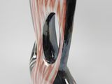 a black and white vase with a pink and black design on it