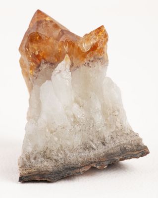 un cristal posé sur un morceau de roche, sur une surface blanche