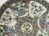 a decorative plate with birds and flowers on it