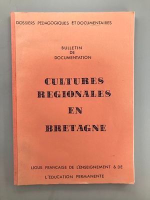 un livre rose avec des inscriptions noires posé sur une table