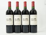 trois bouteilles de vin rouge sont alignées sur une surface blanche