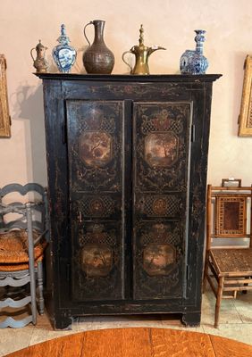 un meuble à porte et une table sur laquelle est posé un vase