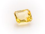 a yellow sapphire stone on a white background