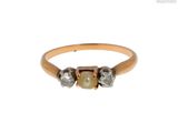 un gros plan d'une bague en or sertie de deux diamants et d'une perle