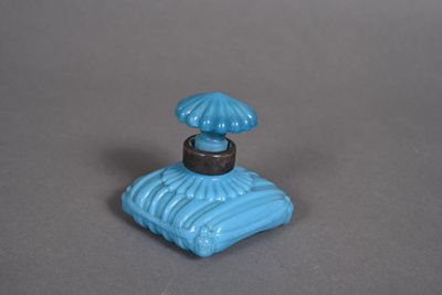 a small blue perfume bottle with an umbrella on top of it