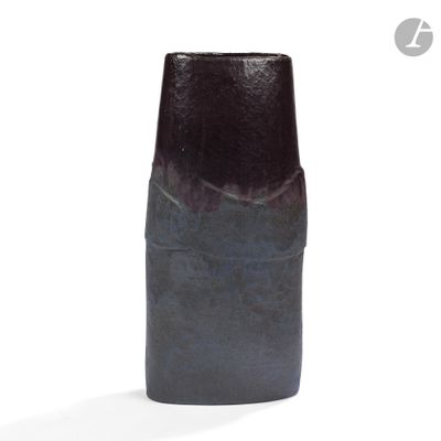 a black vase that is sitting on a white surface