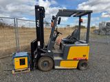 a fork lift truck parked next to a fence