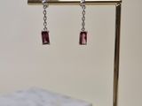 a close up of a pair of earrings sitting on top of a table