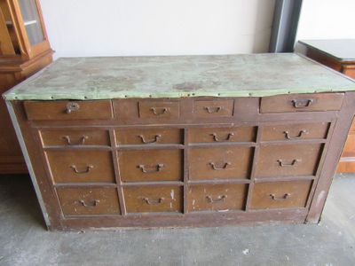 a wooden cabinet with many drawers and a marble top