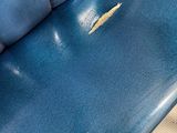 a close up of a blue bench with holes in it