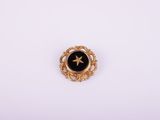 une broche dorée et noire ornée d'une étoile