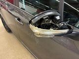 a car that has a denting on the side of it ' s door handle