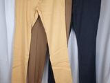 three men ' s pants hanging on a clothes rack in front of a white curtain
