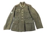une vieille veste militaire avec un écusson sur la poitrine et un autre écusson sur la poitrine