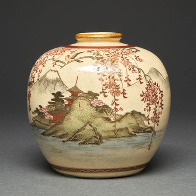 a vase with a painting on it sitting on a table