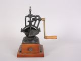 an old fashioned coffee grinder with a wooden handle on a white background
