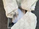 vue de dessus d'un pull blanc au crochet et d'un pantalon dans un bac en plastique
