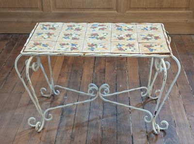 a small table with a tile top on a wooden floor
