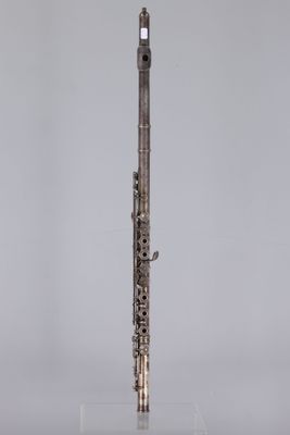 an image of a silver flute on a clear stand