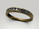 a close up of a gold ring with diamonds on a white background
