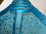 a close up of a blue glass vase on a table