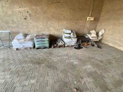 un chien allongé par terre à côté d'une pile de sacs