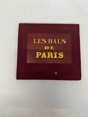 une pancarte sur laquelle on peut lire « Les Bales de Paris » accrochée au mur