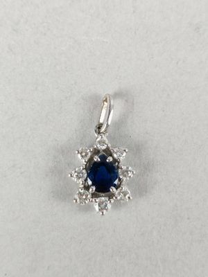 a blue sapphire and diamond pendant on a white background