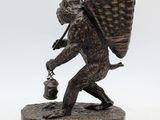 bronze figurine of a boy carrying a basket on his back