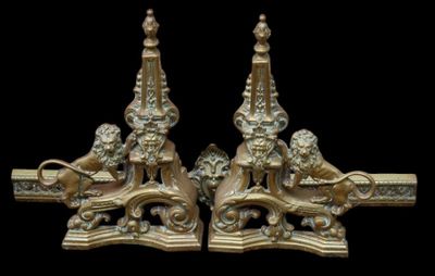a pair of ornately decorated brass candlesticks on a black background