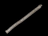 gros plan d'un bracelet en argent sur fond noir