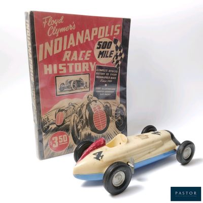 une petite voiture posée à côté d'un livre