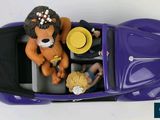 a figurine of a lion sitting in a purple car