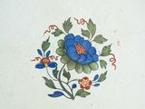 a plate with a blue flower on it sitting on a table