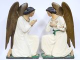 deux figurines d'anges posées sur un socle vert