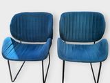 une paire de chaises en velours bleu avec des pieds en métal noir