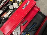a red tool box with tools in it on the floor