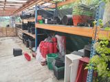many pots and containers on the shelves in the garden