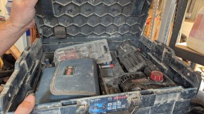 un homme tenant une mallette contenant des outils