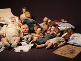 a pile of old dolls on a table with a book