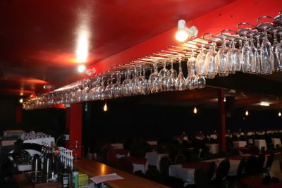 de nombreux verres à vin suspendus au plafond d'un restaurant