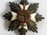 une broche en forme d'étoile ornée d'un motif rouge et or